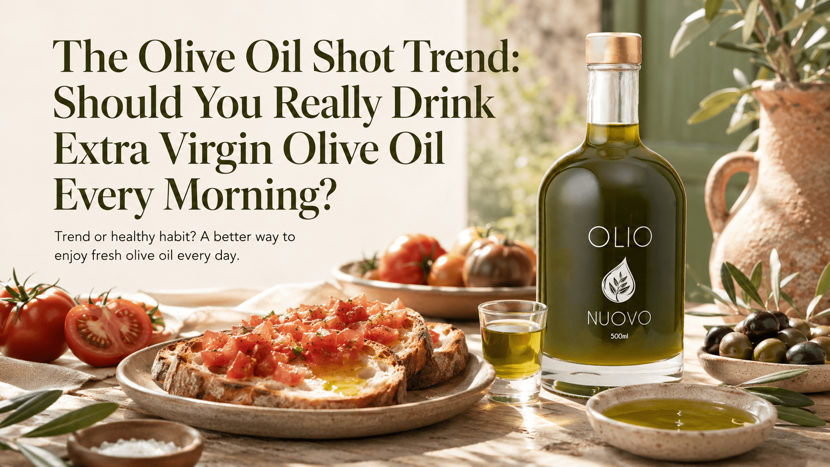 Glass shot of extra virgin olive oil next to fresh olives
